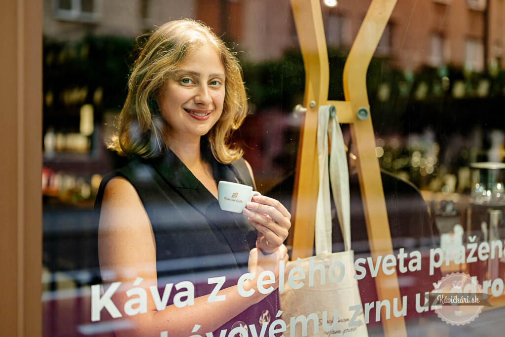 Karin z Casa del Caffè drží šálku kávy s certifikátom Demeter v kaviarni.